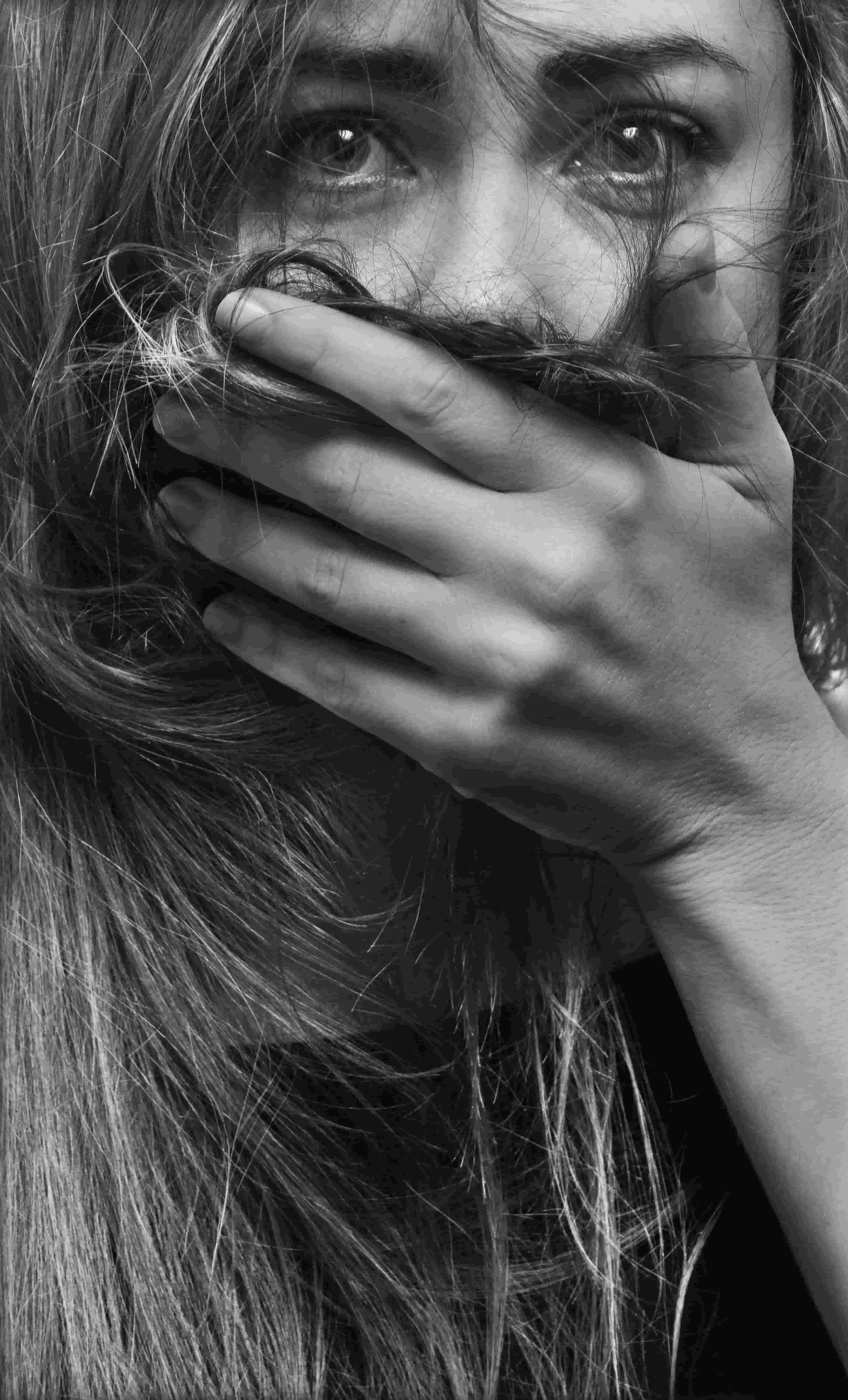 Frau mit sorgenvollem Blick, die Hand vor dem Mund, anhaltende Sorge bei generalisierter Angststörung.